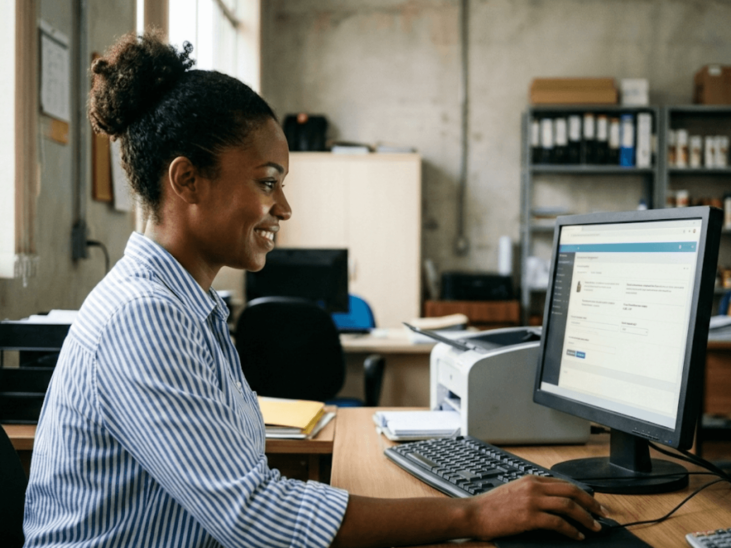 Profissional emitindo nota fiscal pelo sistema no computador do escritório